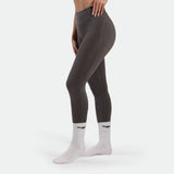 Person wearing gray leggings and white socks with a logo on a white background
