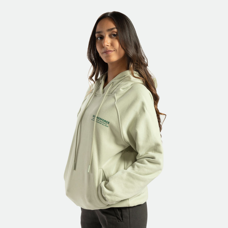 a fit woman wearing hoodie green  with pants 
