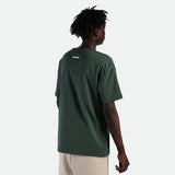 a back view for fit man wearing t-shirt green  with pants  beige 
