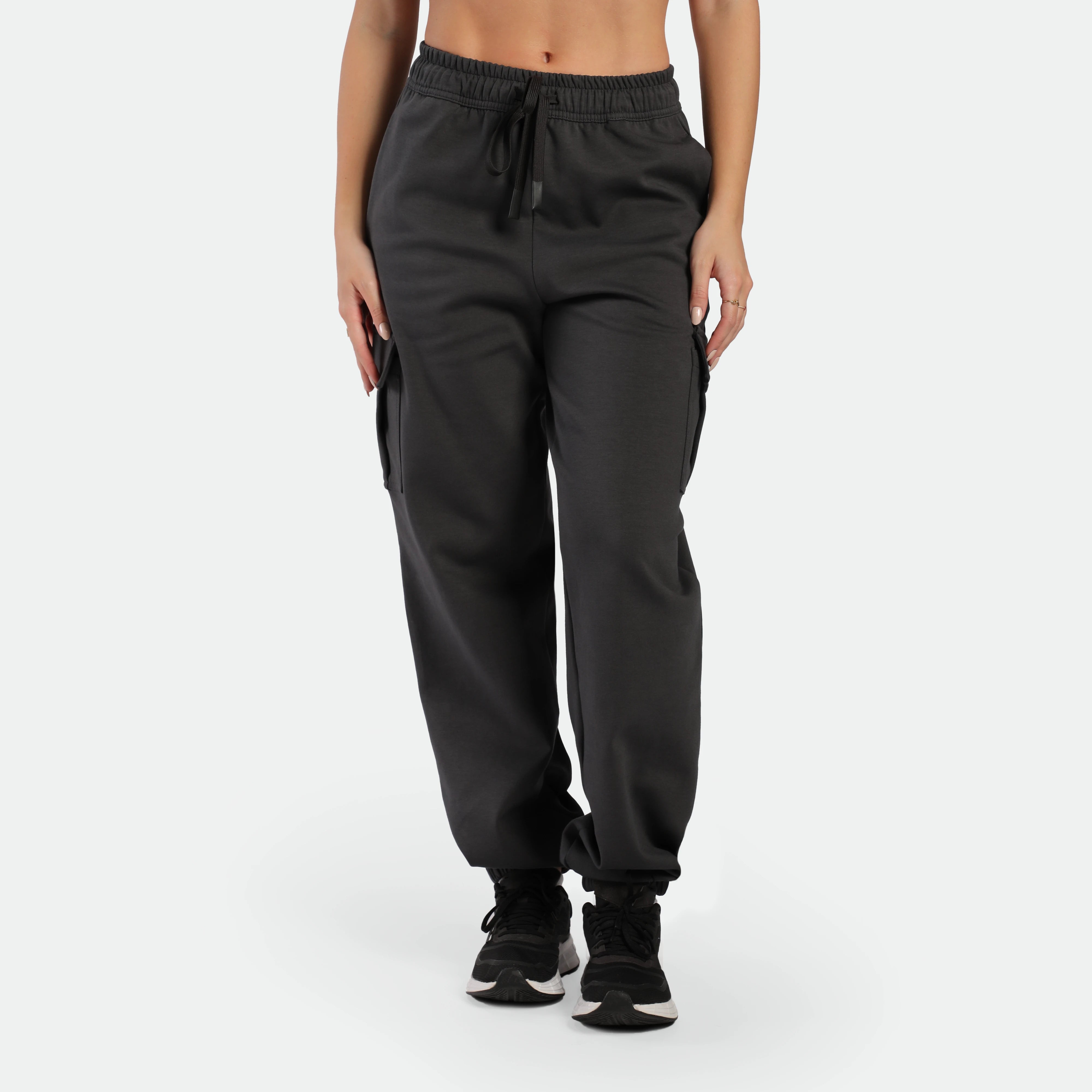a fit woman wearing jogger pants grey ebony with tow pocket in sides and lace ,plus the shoes black 
