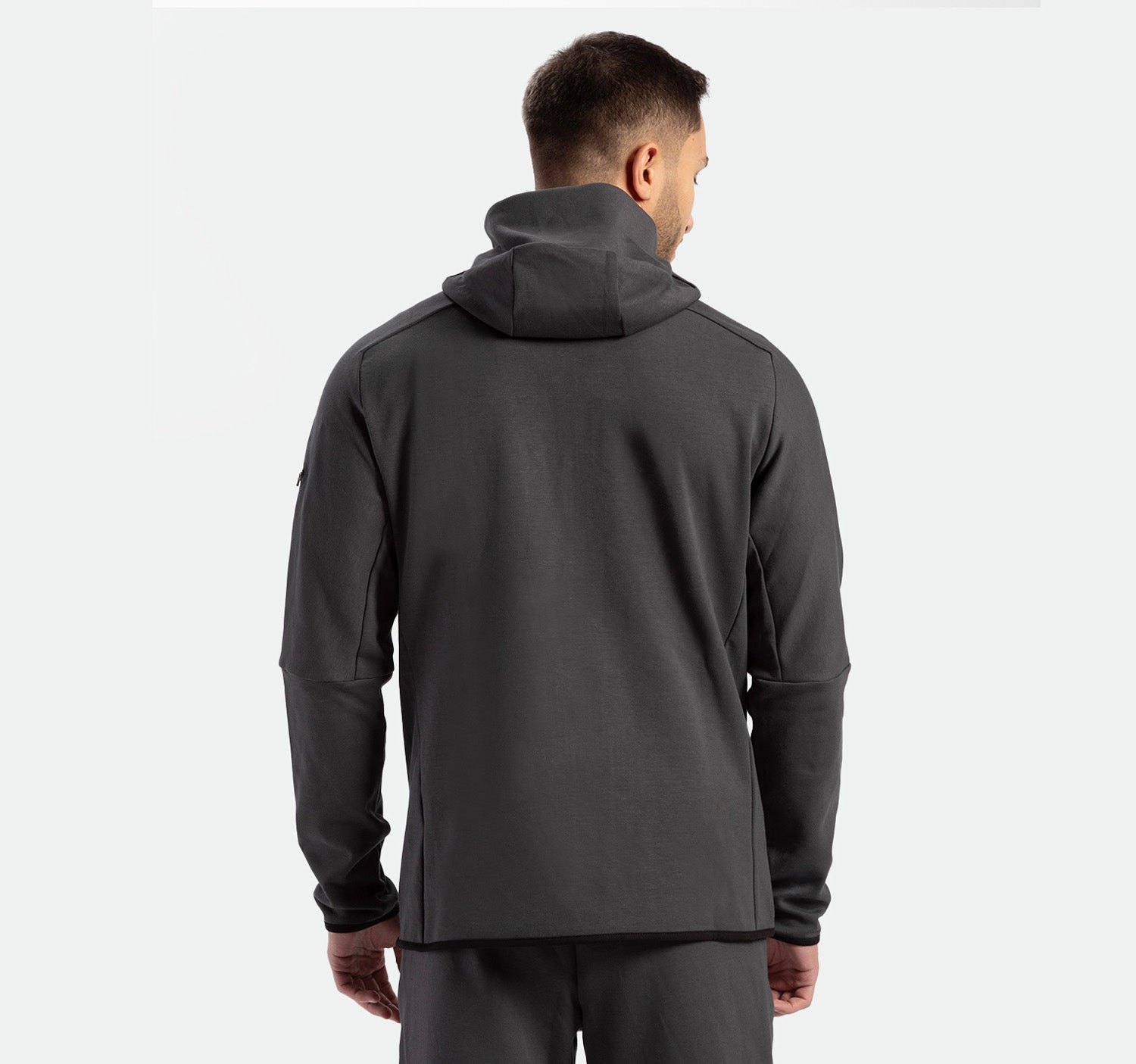 a back view for fit man wearing matching set  grey eboney ,tech zipped hoodie 