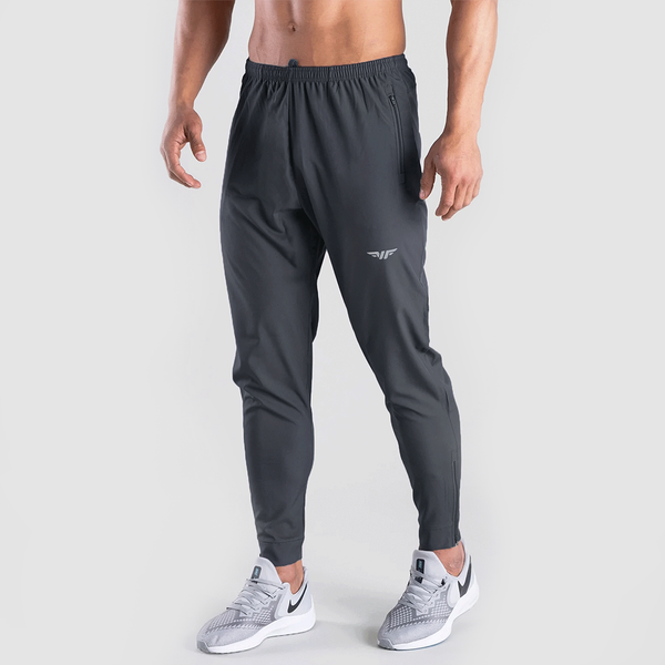 a fit man wearing pants  grey with logo ,plus he wearing shoes 