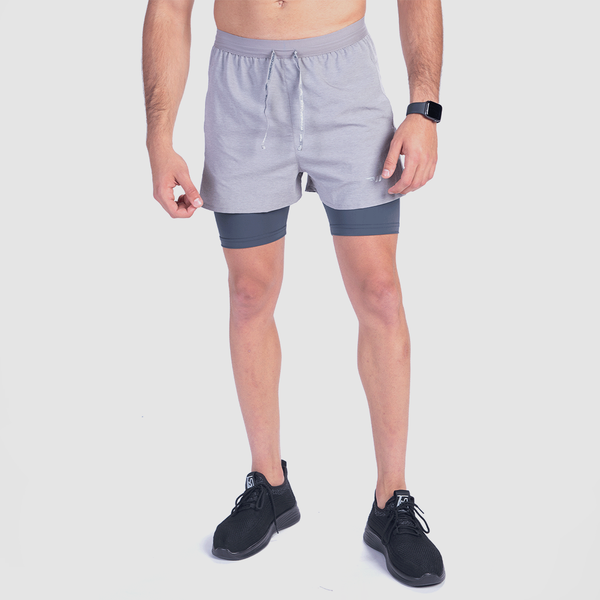 a fit man wearing short  dark grey  2 in 1 with logo plus the shoes black 