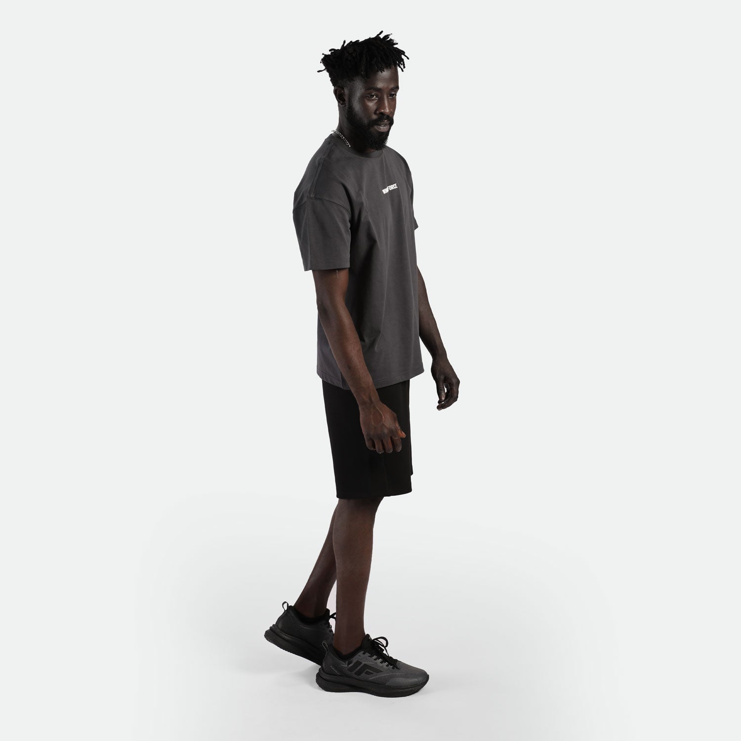 a fit man wearing t-shirt dark grey  with short black ,plus shoes 