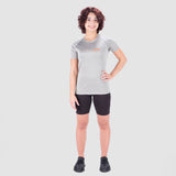 a fit woman wearing t-shirt grey with logo orange and short black  and she wearing sneakers 