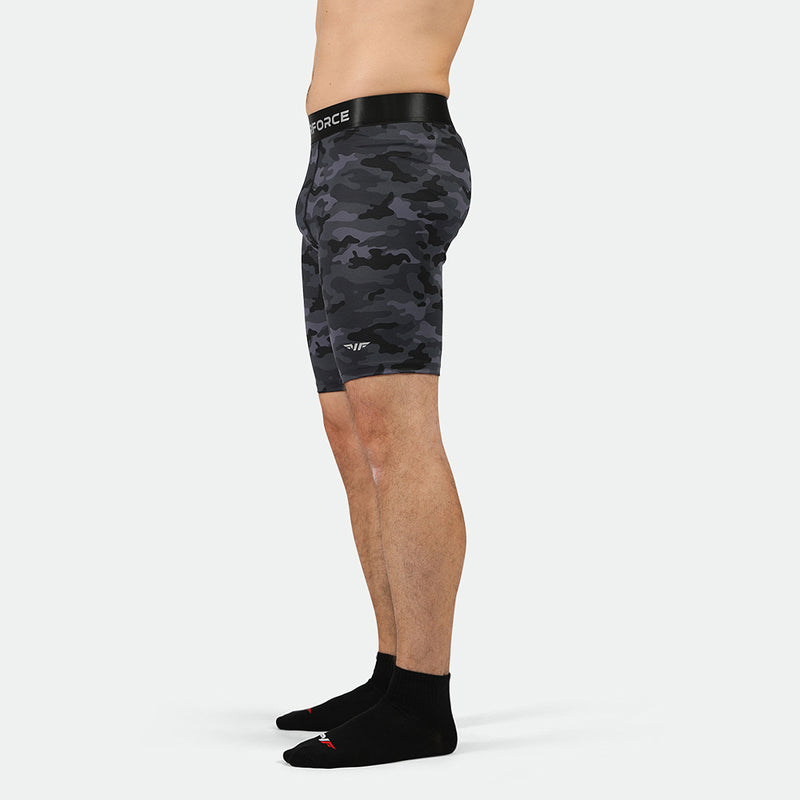 a fit man stand at right and wearing short grey toned camo with socks black 