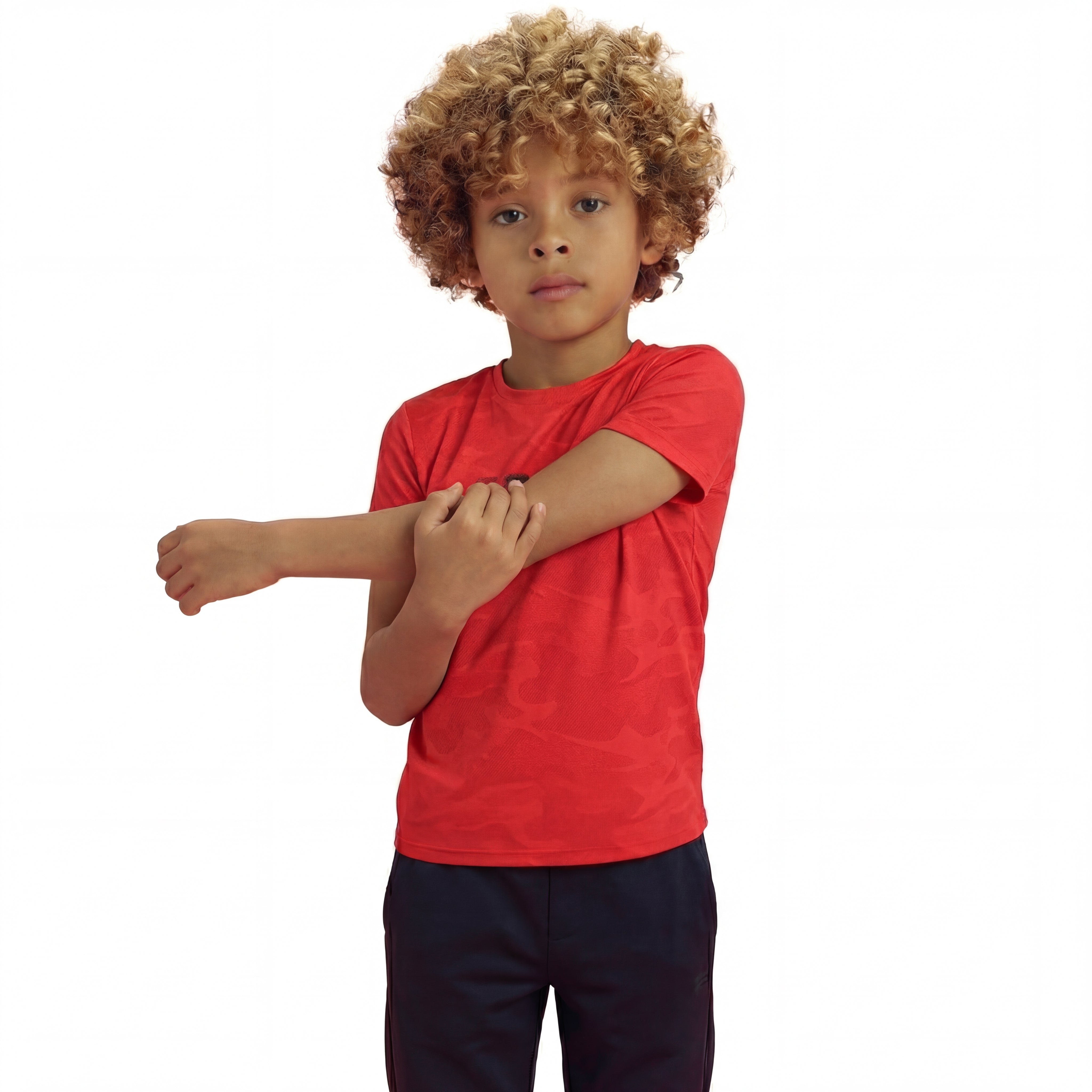 A boy posing and wearing a regular fit camo t-shirt in the color high risk red. He is also wearing navy pants.