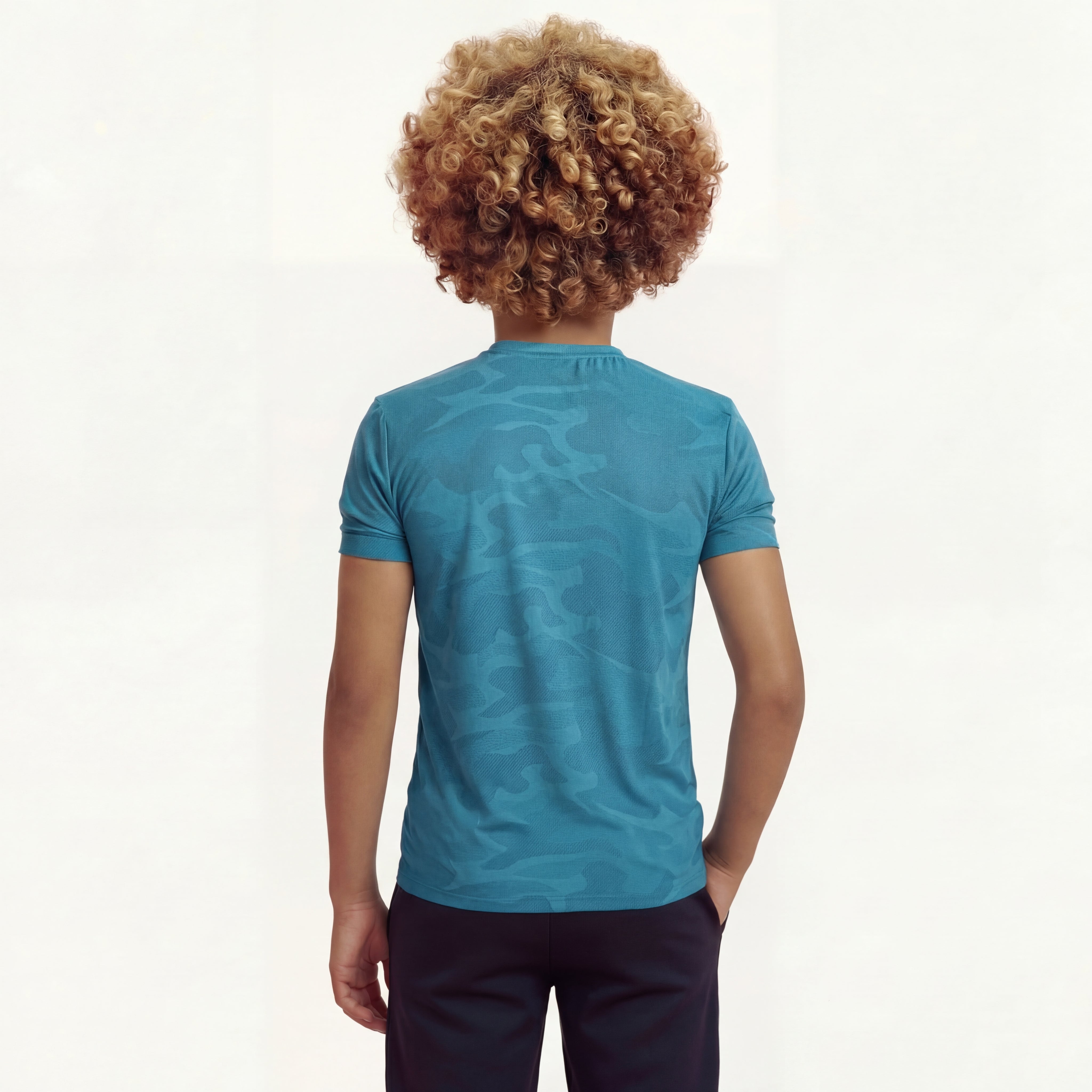 Back view of a boy wearing a regular fit saxony blue camo t-shirt. He is also wearing navy pants.