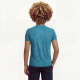 Back view of a boy wearing a regular fit saxony blue camo t-shirt. He is also wearing navy pants.