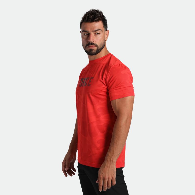 a fit man stand at right and wearing t-shirt high risk red with pants black 