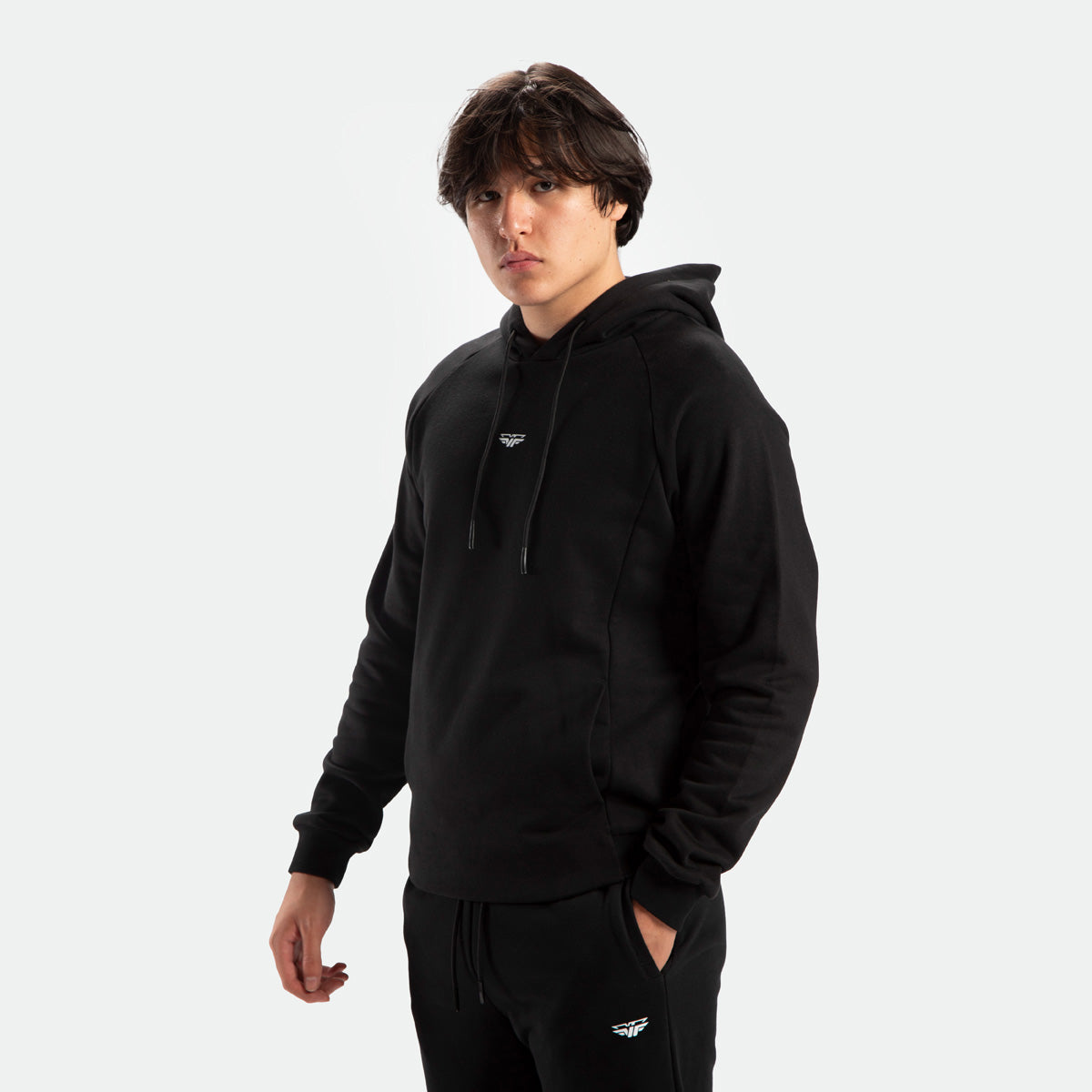 a fit man stand at right and wearing matching set hoodie and pants