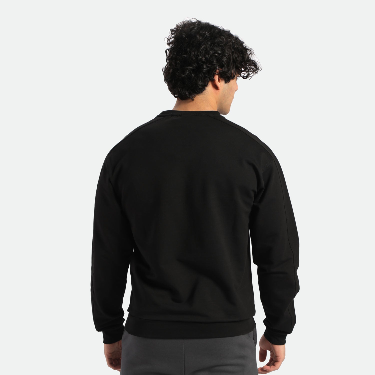 a back view for fit man wearing t-shirt black and pants grey