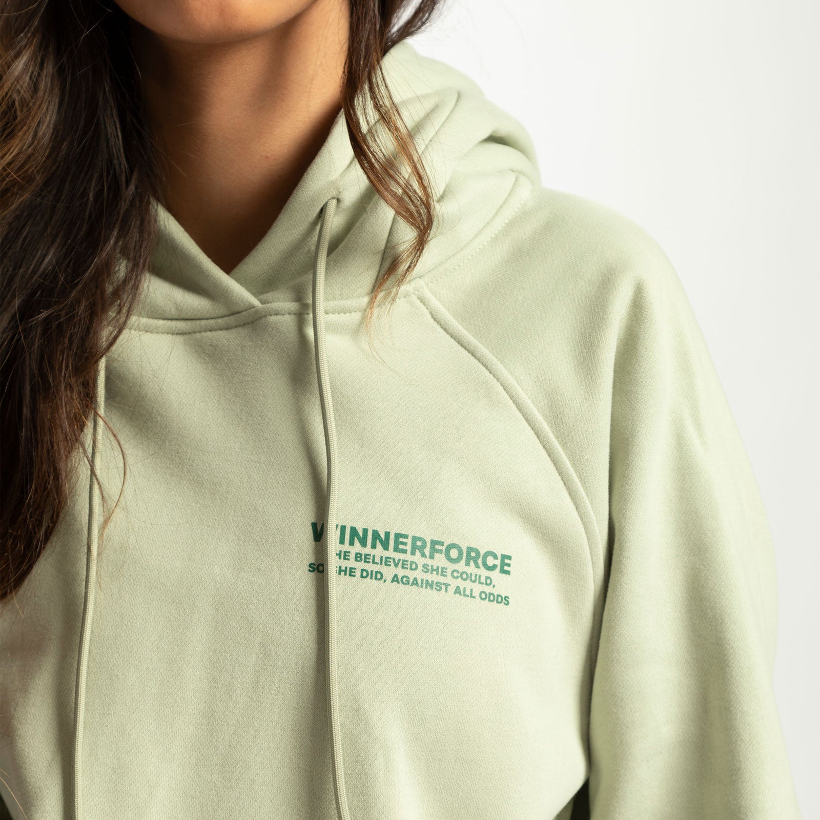 close up view for fit woman wearing hoodie  green with logo 