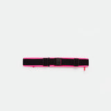 A hot  pink  utility belt with an adjustable buckle and two side straps, displayed on a plain white background.