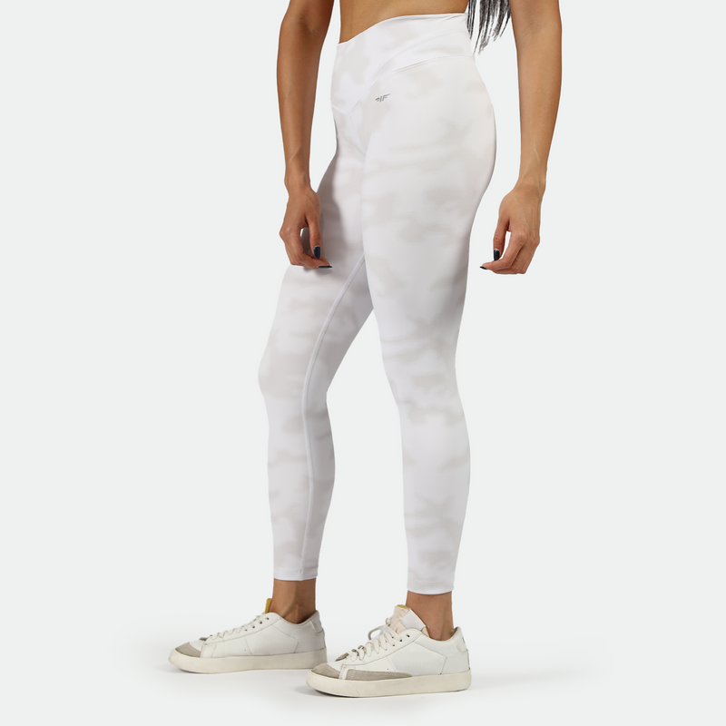  a fit woman stand at right and wearing legging illuminated white  with shoes ,plus the background is light grey  