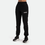 a fit woman wearing jogger pant with logo white on front ,she wearing black a athletic shoes ,plus the background is light grey 