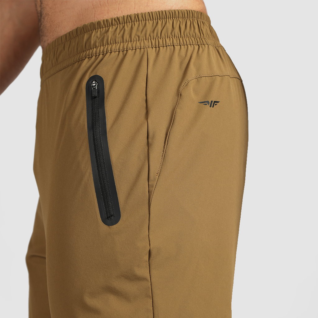 close up view for fit man stand at right and wearing pants khaki  with logo 