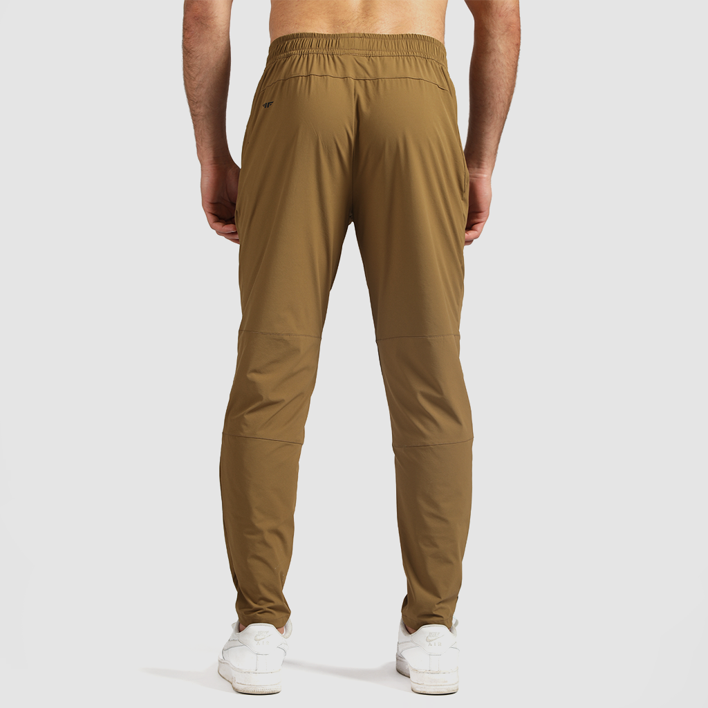a back view for fit man wearing pants khaki with shoes white  