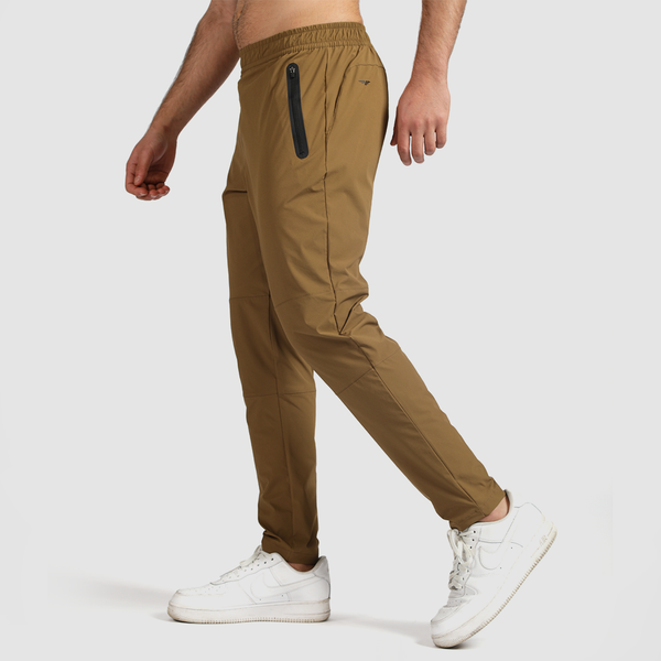 a fit man stand t right  and wearing pants khaki  brown with shoes white 