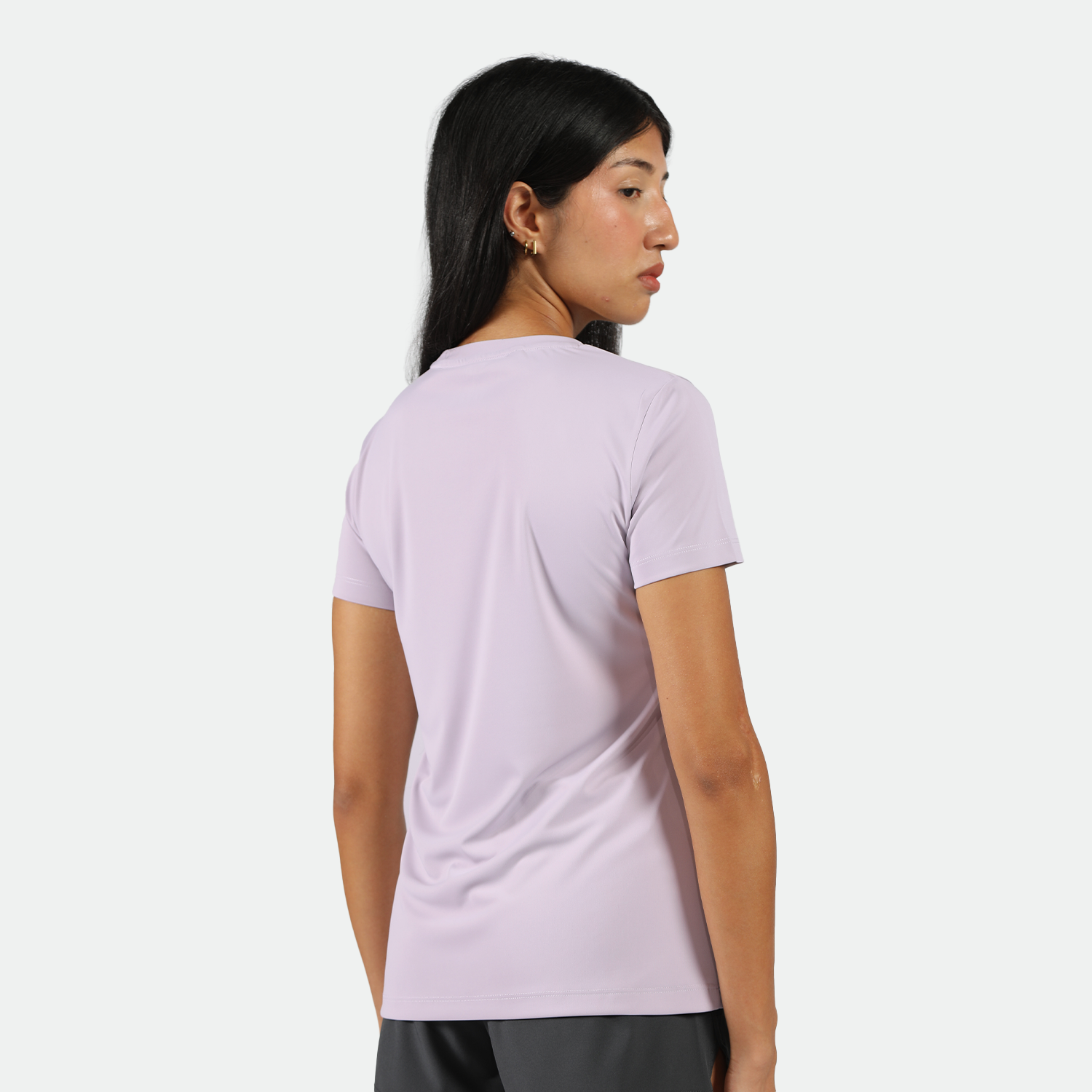 a back view for fit woman wearing  a light purple athletic t-shirt, black shorts ,plus the background is light grey 