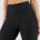  a fit woman  wearing legging black with background light grey