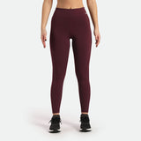 a fit woman wearing  legging red with logo white and she wearing shoes black ,plus background light grey