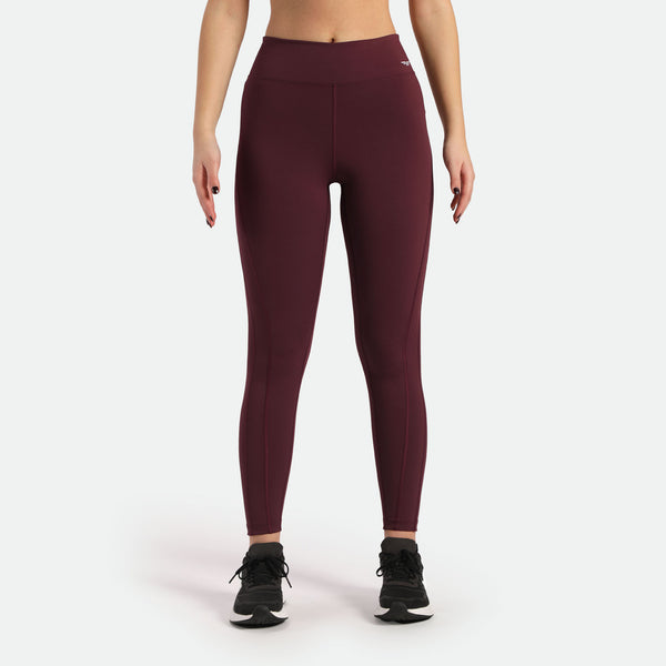 a fit woman wearing  legging red with logo white and she wearing shoes black ,plus background light grey