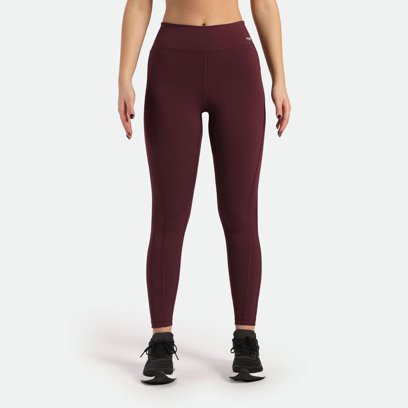 a fit woman wearing  legging red with logo white and she wearing shoes black ,plus background light grey