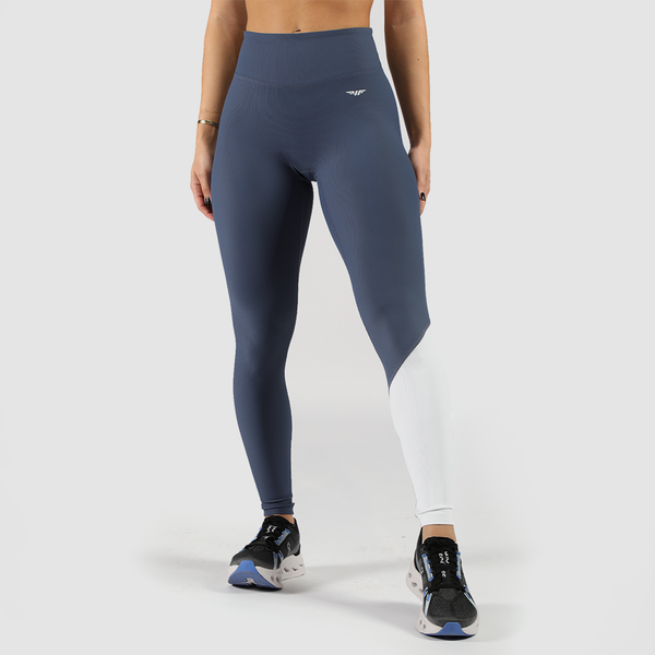 a fit woman  wearing legging mix  two color  blue and white , with logo white,  plus the shoes is same  color ,the background is light grey 