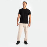 a fit man wearing t-shirt  black with pants beige  plus shoes 