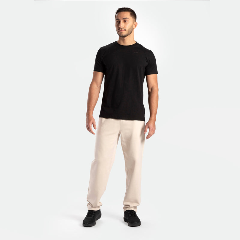a fit man wearing t-shirt  black with pants beige  plus shoes 