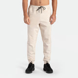 a fit man wearing pants light  beige  with shoes black