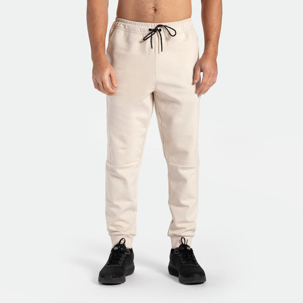 a fit man wearing pants light  beige  with shoes black