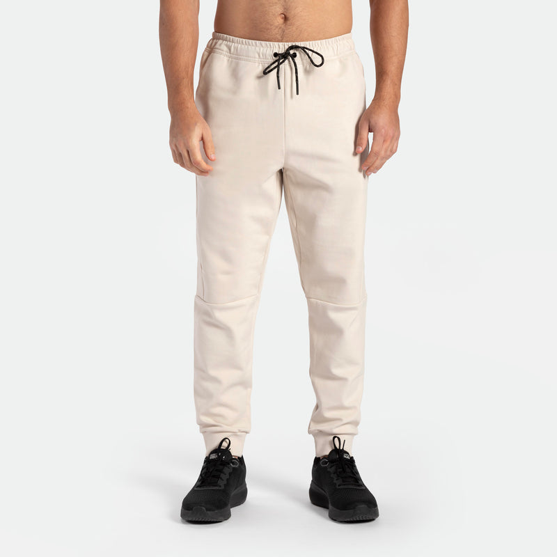 a fit man wearing pants light  beige  with shoes black