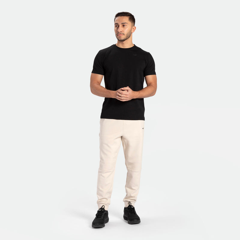 a fit man wearing t-shirt black with pants beige ,plus shoes black 