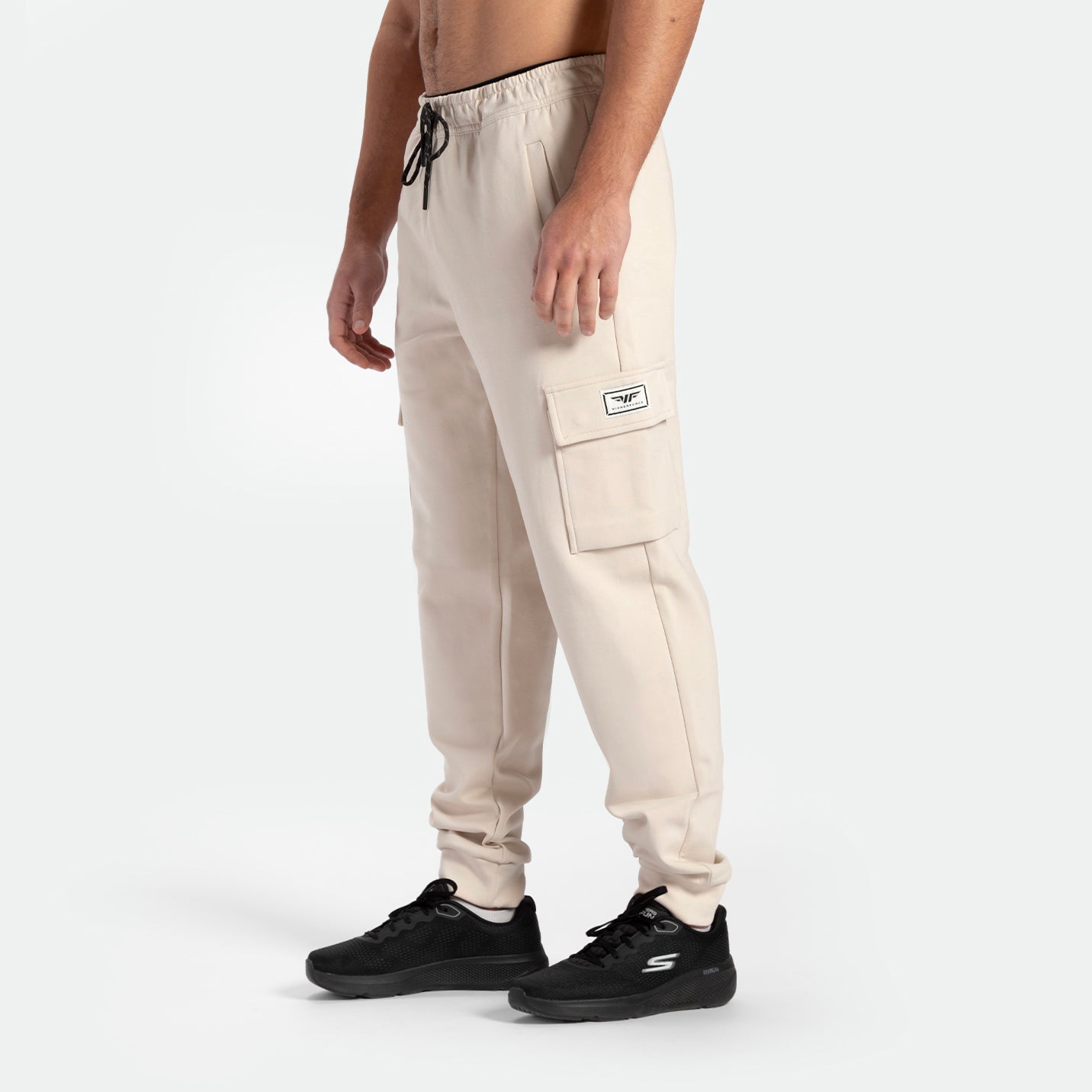 a fit man wearing  jogger pants light beige with shoes  black 