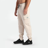 a fit man wearing  jogger pants light beige with shoes  black 