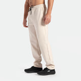 a fit man wearing pants beige with shoes black 