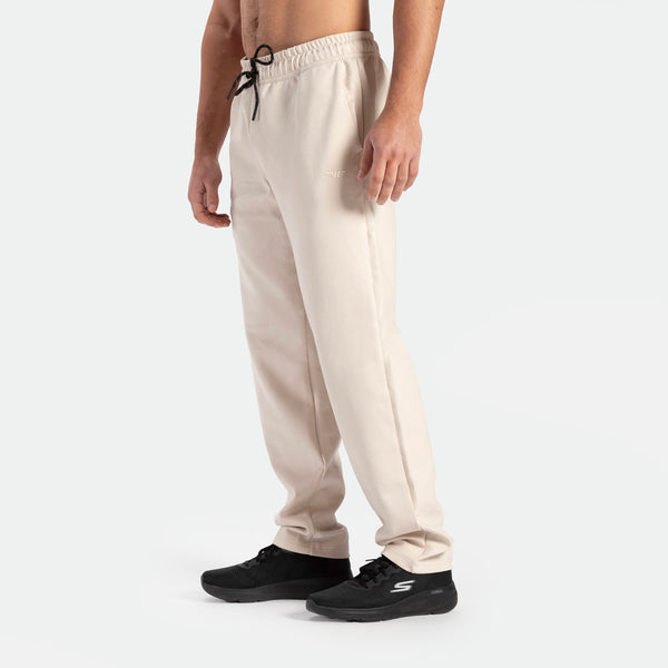 a fit man wearing pants beige with shoes black 