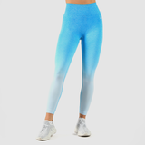a fit woman wearing legging a blue gradien with logo white ,the logo and shoes is same logo ,plus background is light grey 