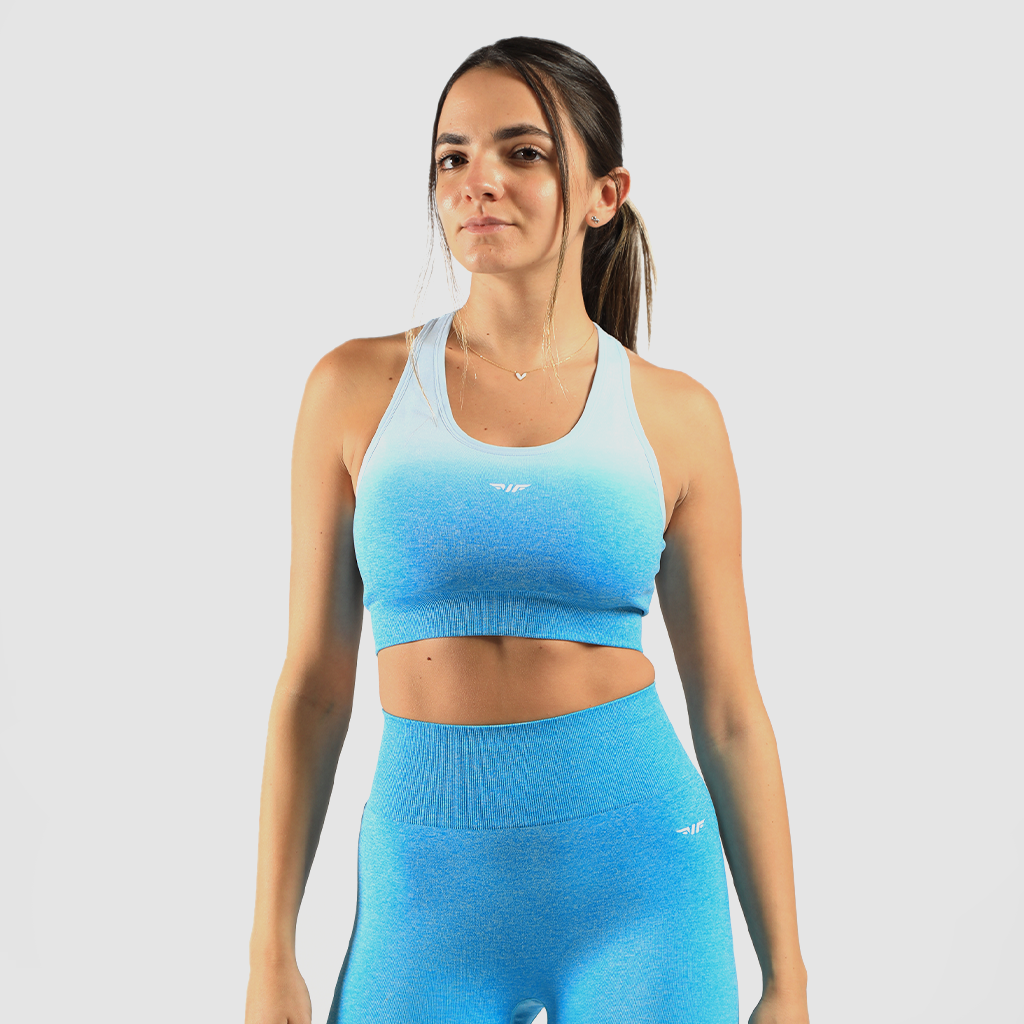 a fit woman wearing matching bra and legging a blue gradien and logo white ,the background is light grey 