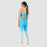 a back view for  fit woman wearing matching bras and legging  a blue gradien with shoes white ,plus the background is light grey 
