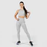  a fit woman  wearing matching bra and legging with logo black and shoes , she look at the camera with pose ,the background is light grey 