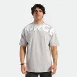 a fit man look at camera ,he wearing t-shirt light grey with logo and pants black 
