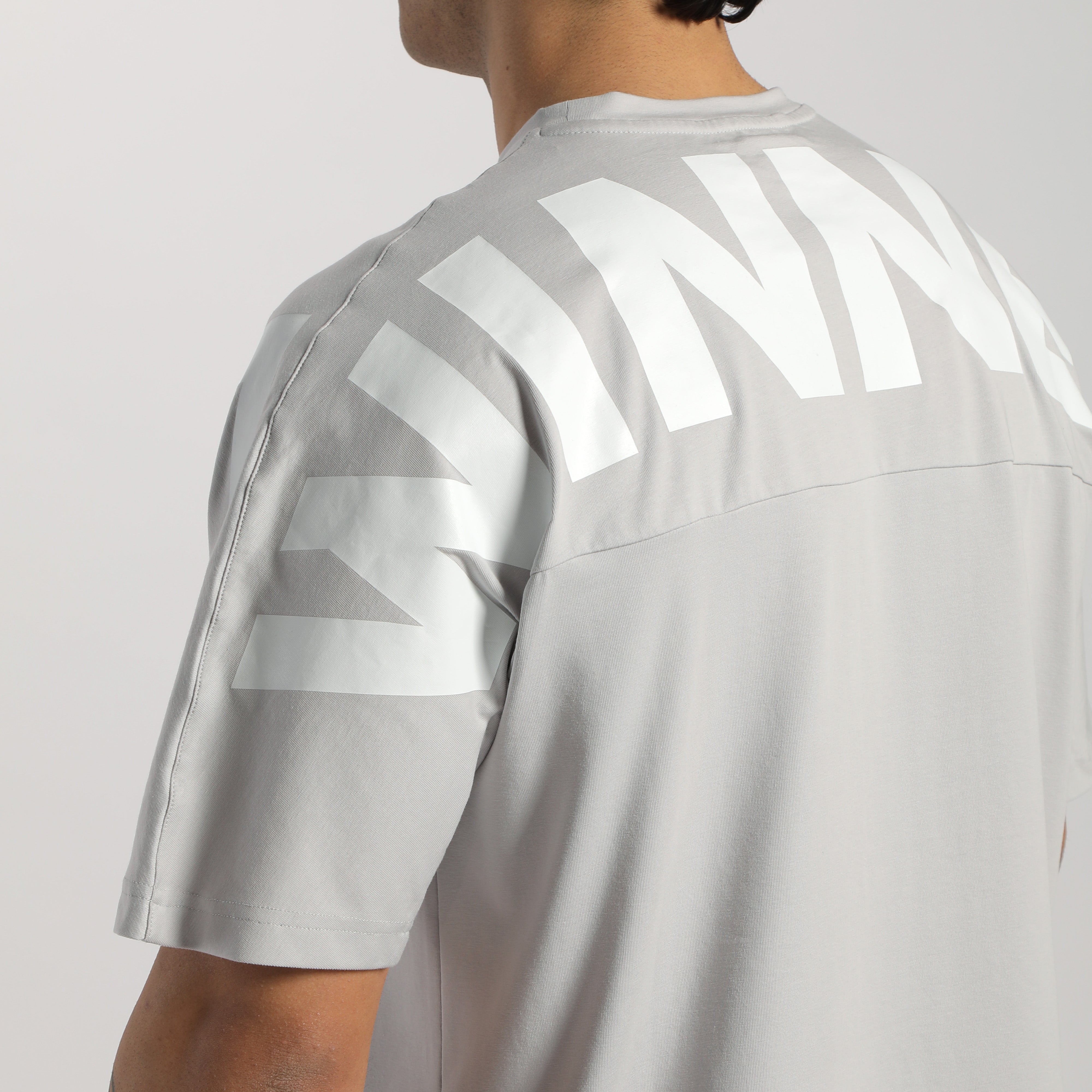 a back view for man wearing t-shirt  light grey with logo 