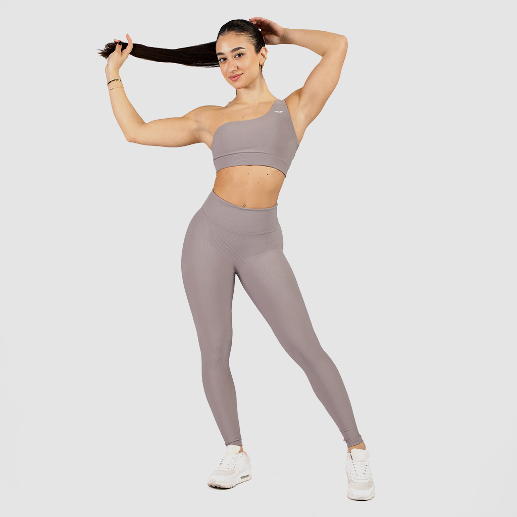a woman wearing matching bra and legging  grey with background light grey