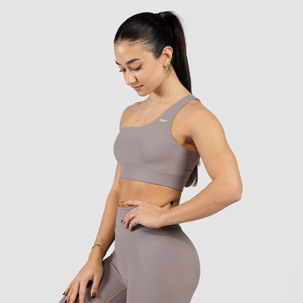 Model wearing a stylish grey sports bra and leggings presenting a modern and sporty look, along with a light grey logo and background