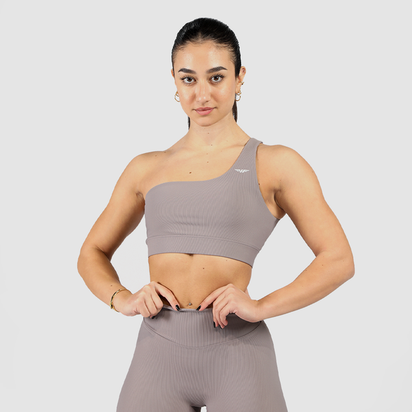 Model wearing a stylish grey   sports bra and leggings presenting a modern and sporty look, along with a light grey logo and background 