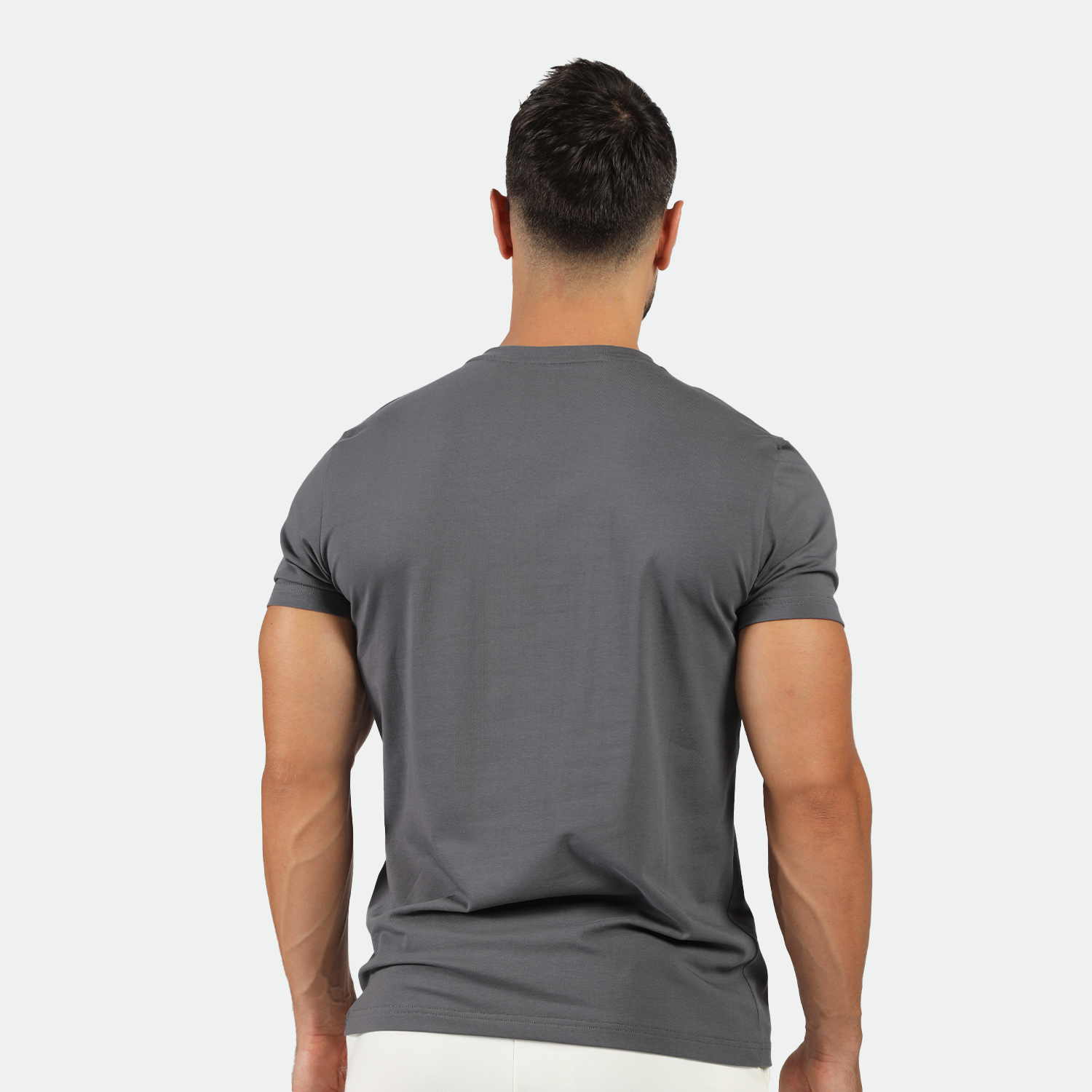 a back view for fit man wearing t-shirt magnet dark grey with short white 