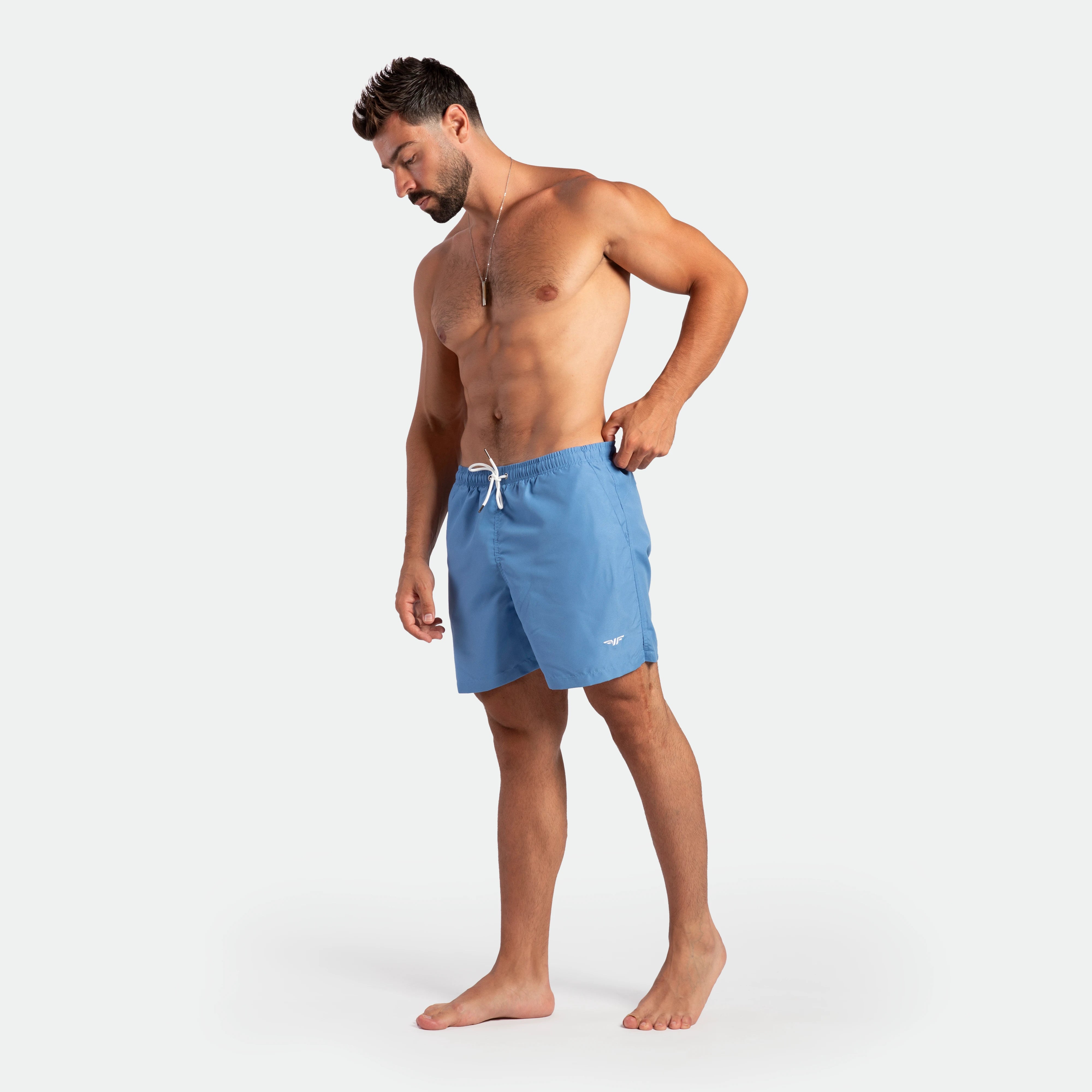 a fit man stand at right an wearing short marina blue 